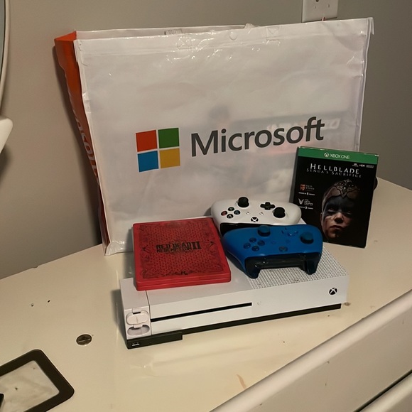 Xbox one S 1 T, with 2 controllers, 2 games, and a rechargeable battery.